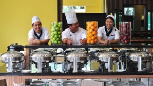 A buffet setup with multiple food stations, including fruits and covered dishes. - Dreamtel Kota Kinabalu (Kota Kinabalu)