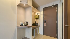A modern hotel room with a kitchenette, a door with a 'Do Not Disturb' sign, and a small shelf with a kettle and bottles. - Palette KL Sentral Station Formerly Scott Hotel (Kuala Lumpur)