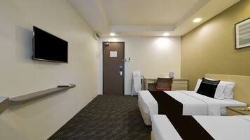 A hotel room with two beds, a TV, a desk, and a chair.