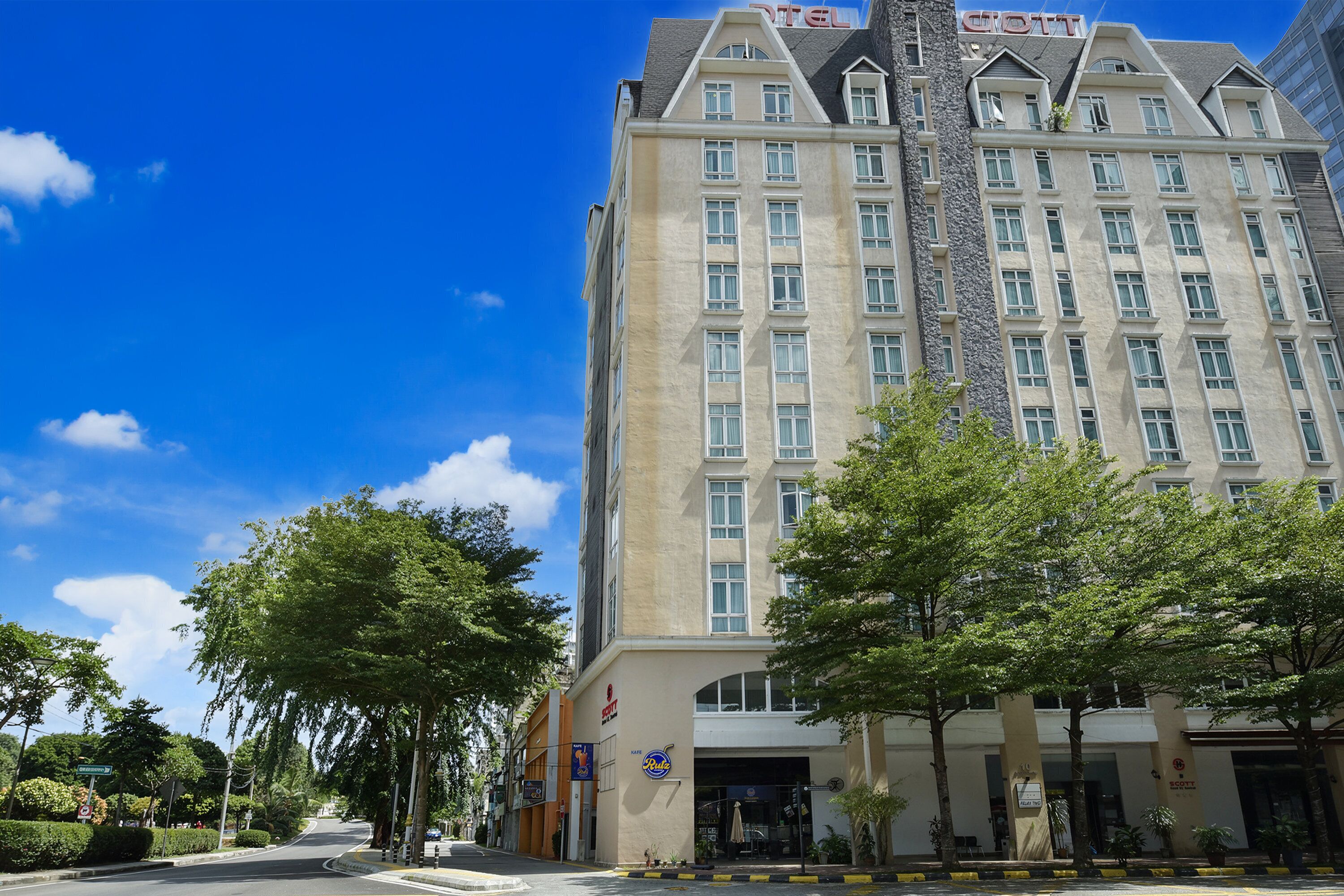 A multi-story hotel with a prominent entrance, large windows, and a clear sky.