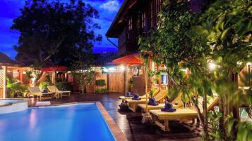 Una piscina al aire libre, sombrillas, tumbonas