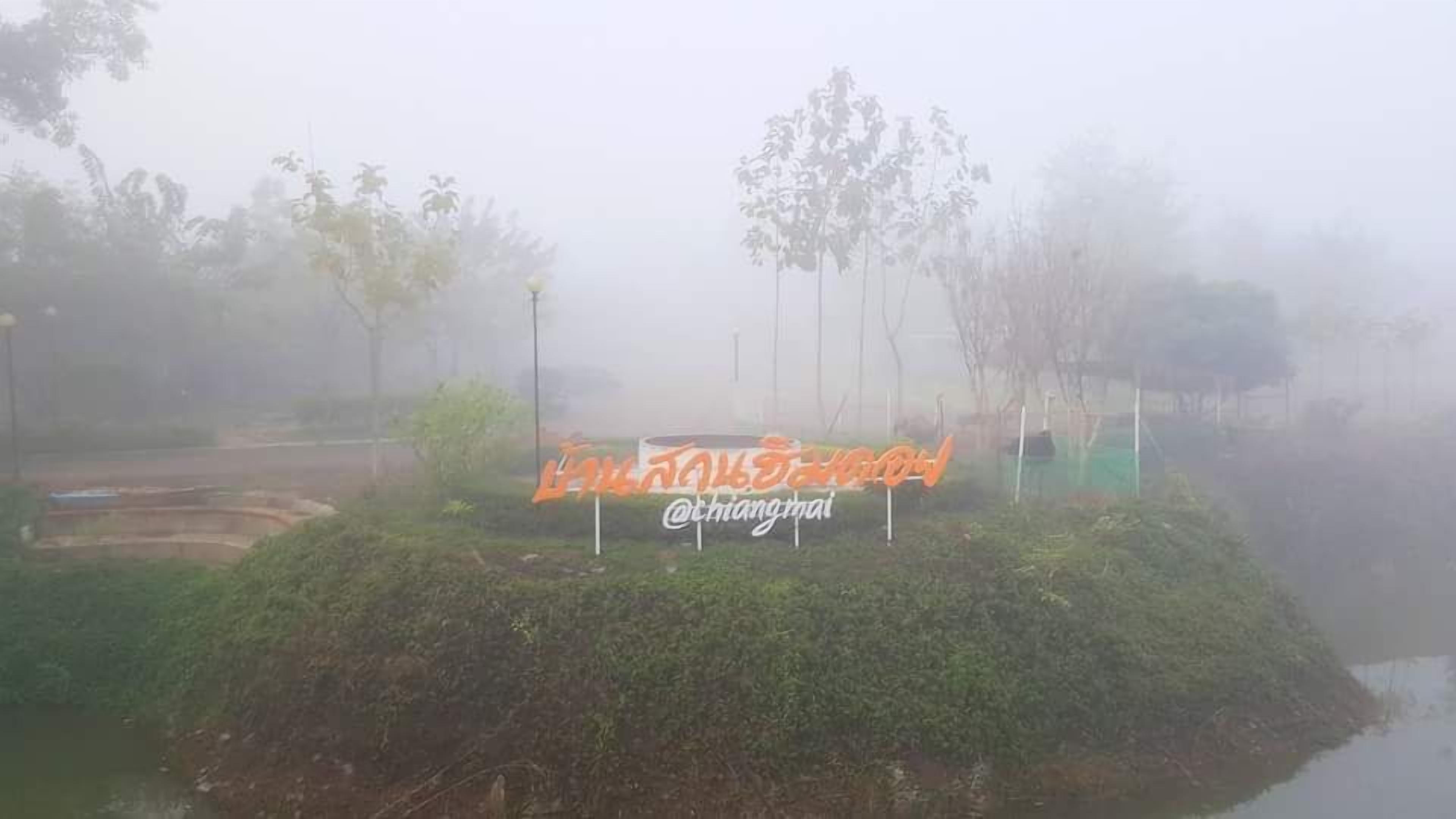 Een mistig landschap met een bord op een klein eiland.