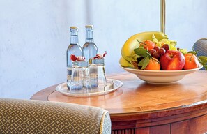 Una mesa con un bol de fruta, saleros y dos botellas.