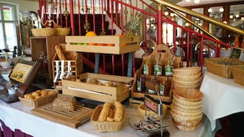 Een ontbijtbuffet met brood, gebak, fruit en toevoegingen.