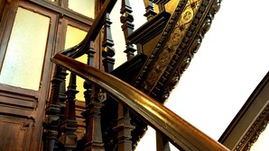 A grand staircase with ornate woodwork and a glass balustrade.