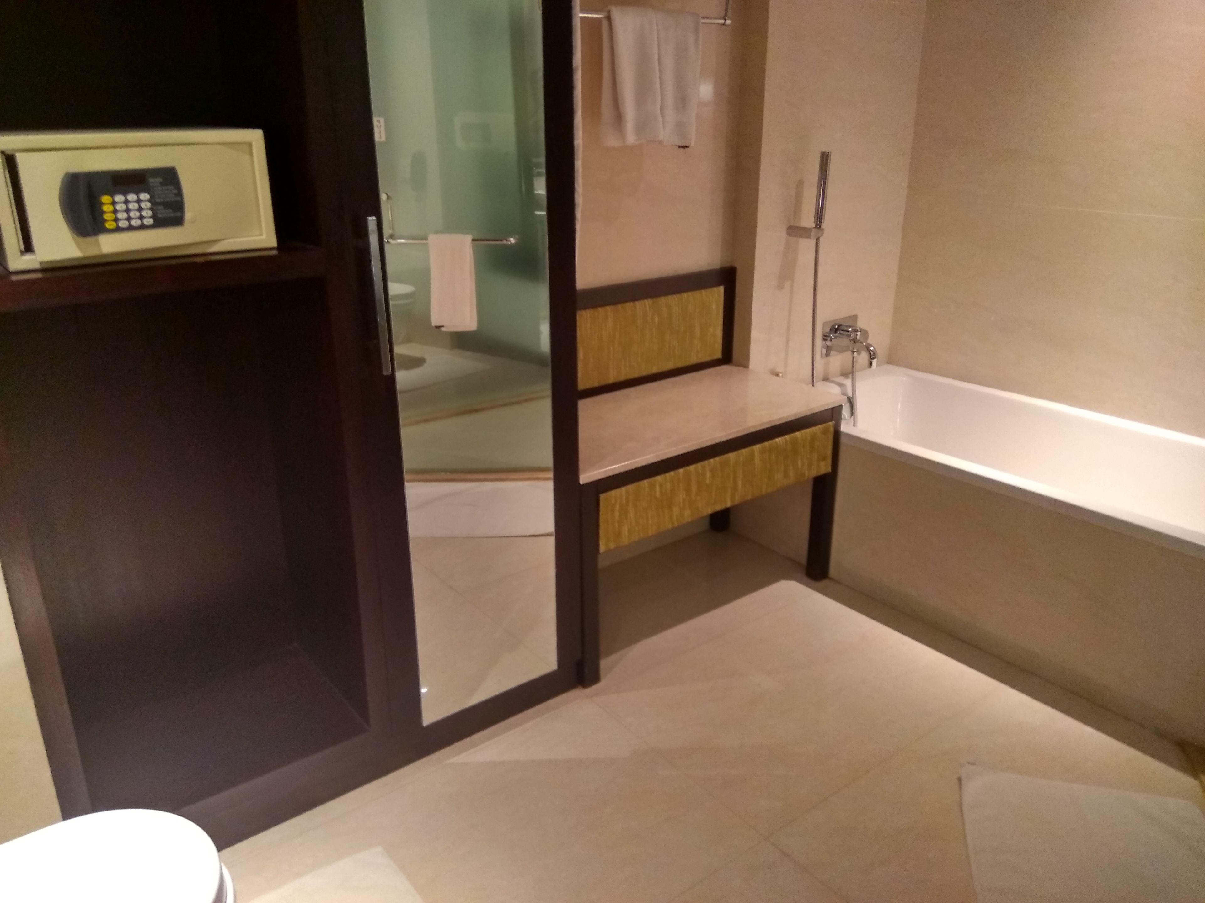 A modern bathroom with a bathtub, a vanity with a mirror, and a toilet.