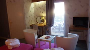 Habitación de hotel con dos camas, un escritorio, una silla, un televisor y una ventana con vistas al exterior.