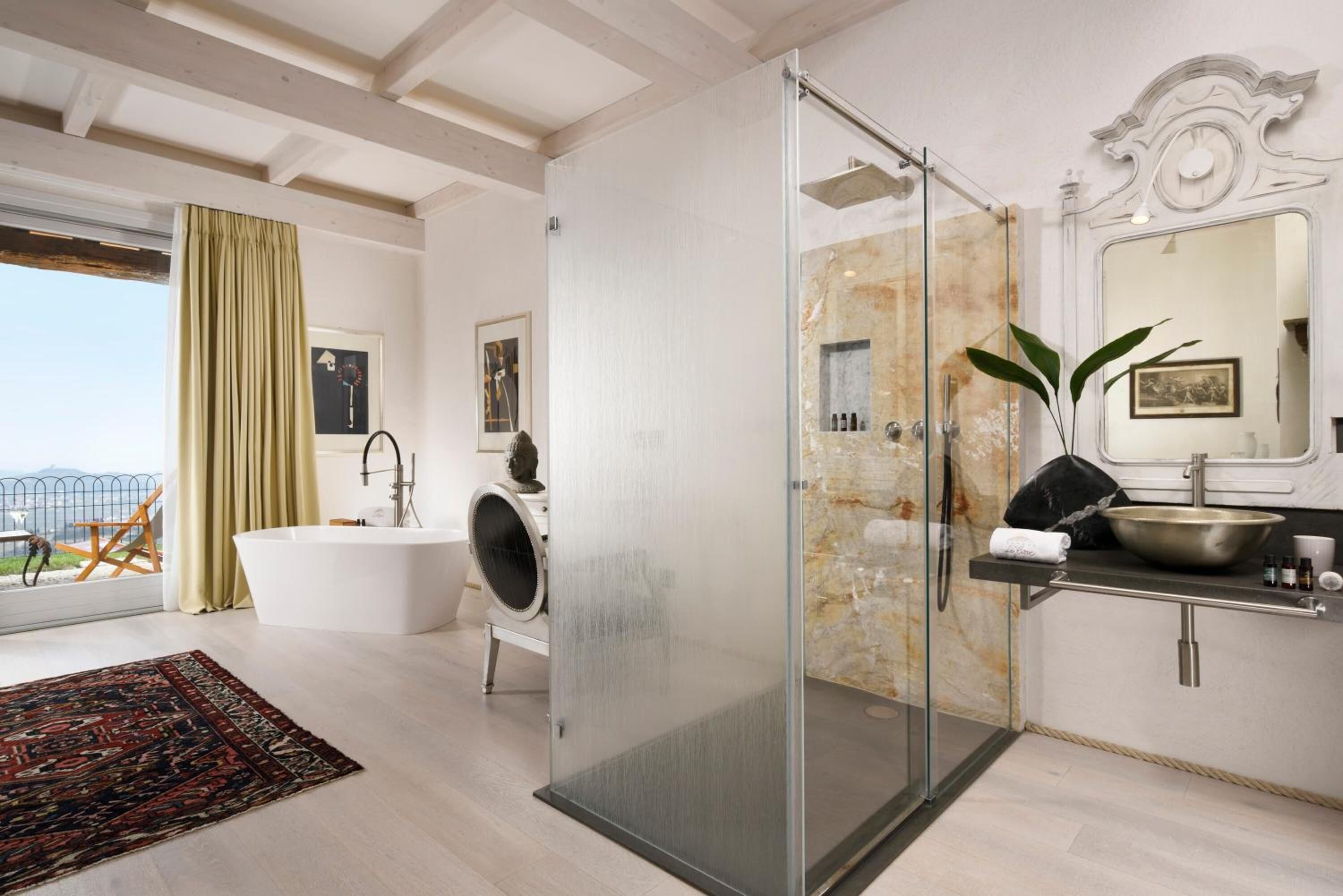 Un baño moderno con ducha envuelta en vidrio, una bañera independiente y un tocador con un espejo grande.
