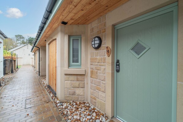 A building with a stone facade, a green door, and a small window. - Bankton House Hotel (Livingston)