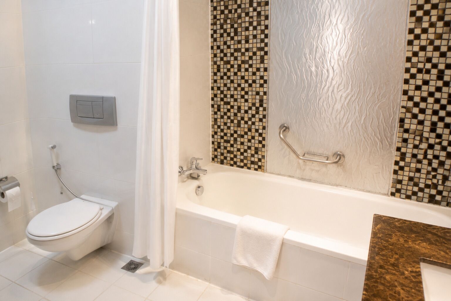 A bathroom with a toilet, a bathtub, and a shower.
