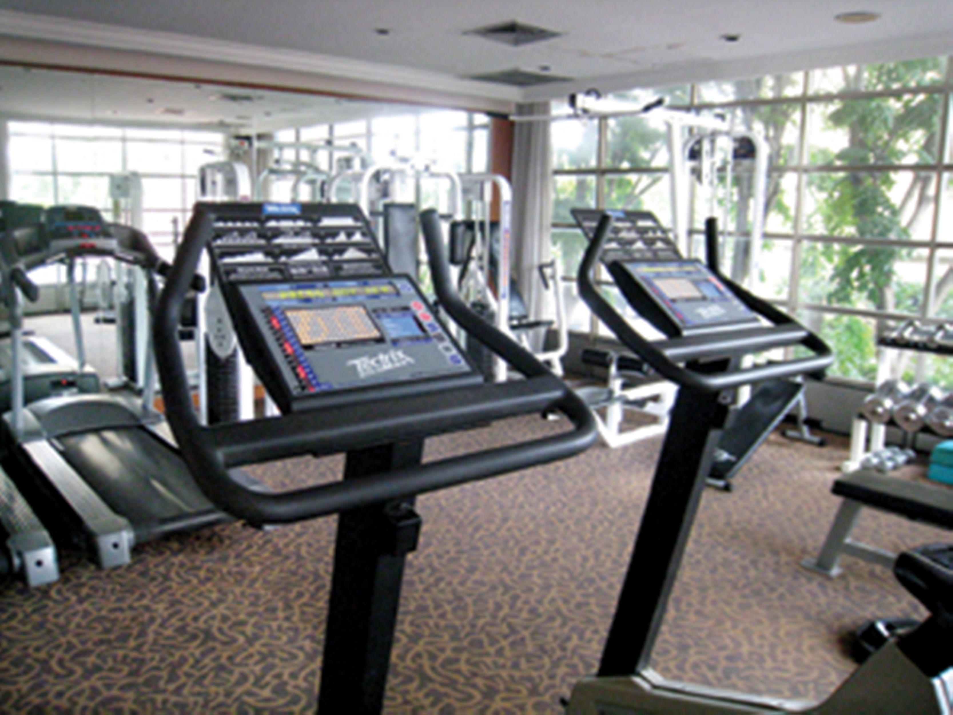 A gym with treadmills, weight machines, and exercise equipment.