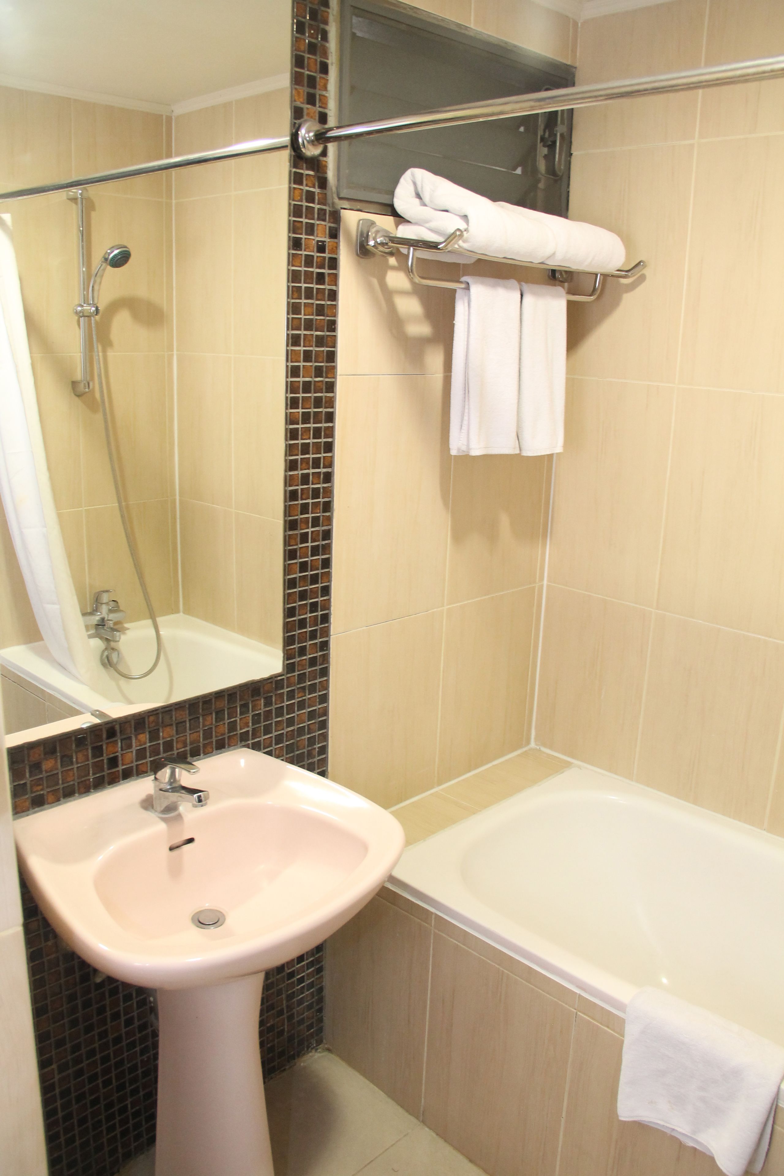 Baño con lavamanos, espejo, ducha y bañera.