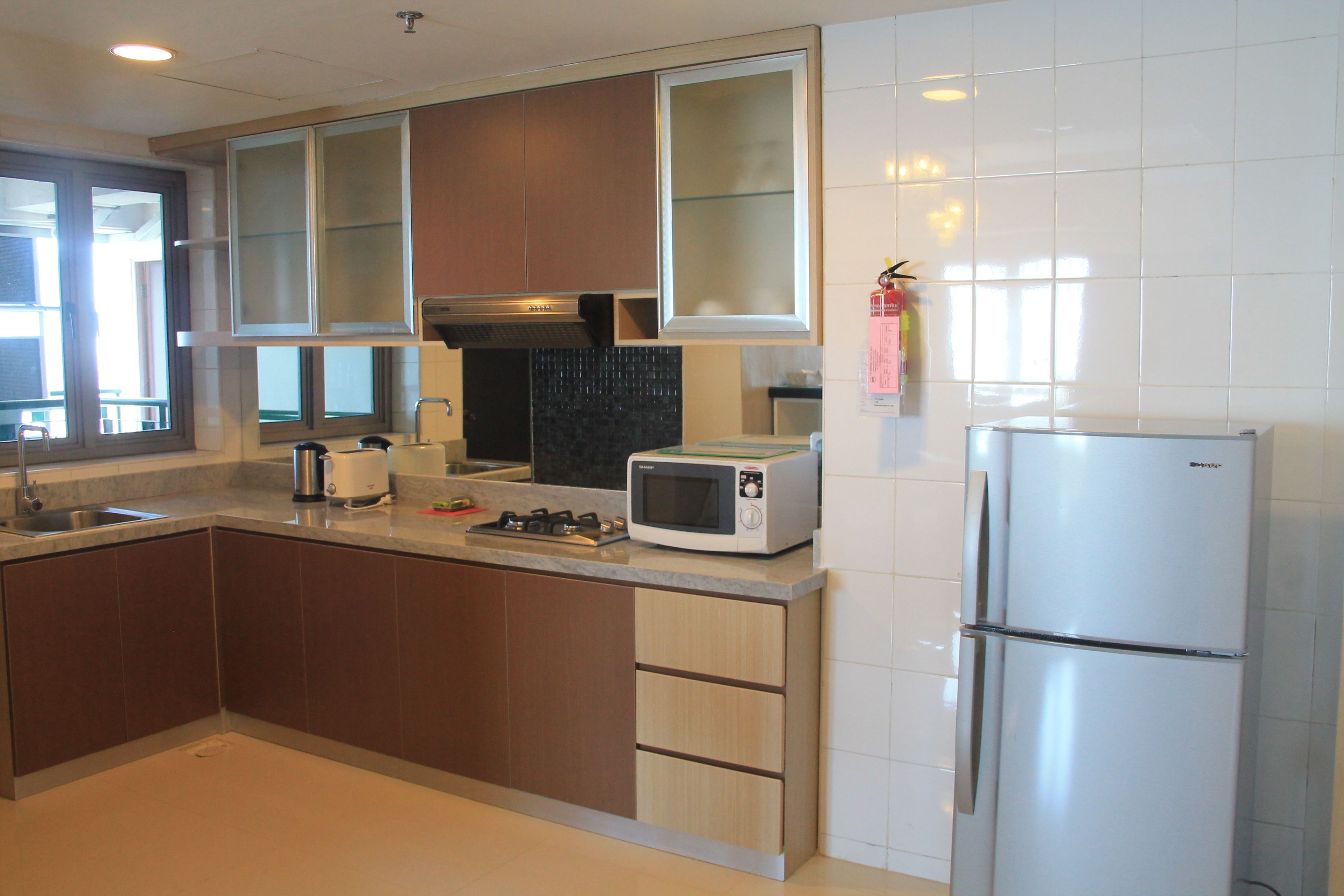 A modern kitchen with a microwave, toaster, and refrigerator.