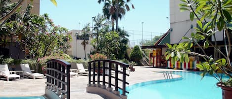 Alberca al aire libre y camastros