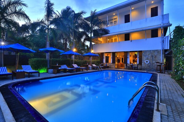 Alberca al aire libre, sombrillas en la alberca y camastros 