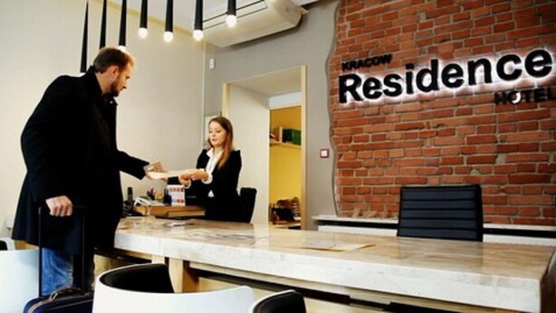 A reception desk with a brick wall and a sign that reads "KRACOW Residence Hotel". - Kracow Residence Hotel (Krakow)
