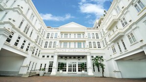 A large, white building with the name "The Sterling" on the facade. It features multiple windows and a central entrance with a set of steps leading up to it. - The Sterling (Malacca City)