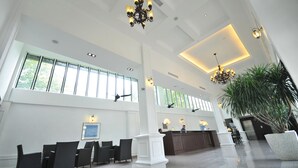 A spacious lobby with high ceilings, large windows, and modern chandeliers. - The Sterling (Malacca City)