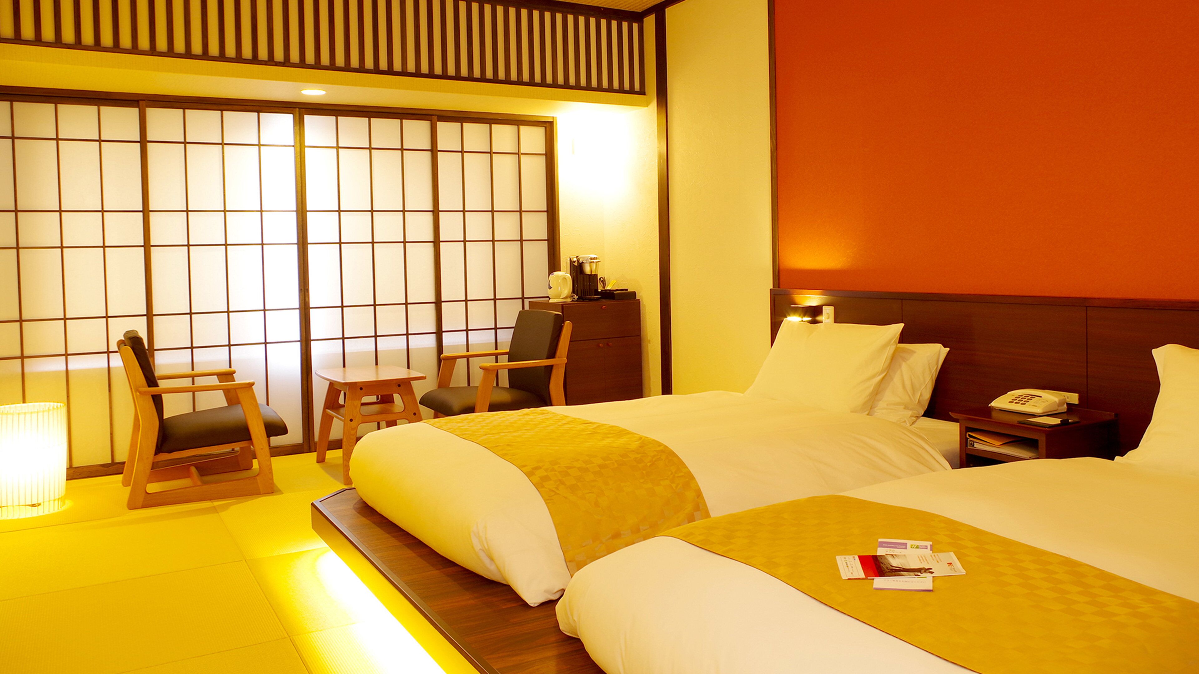 A hotel room with two beds, a desk, a chair, and a traditional Japanese sliding door.