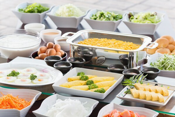 A buffet with various dishes including eggs, salads, and other food items.