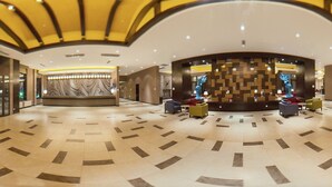 A spacious lobby with a geometric floor pattern, a central seating area with colorful chairs, and a decorative wall with a tree sculpture. - Holiday Inn Express Changbaishan by IHG (Baishan)