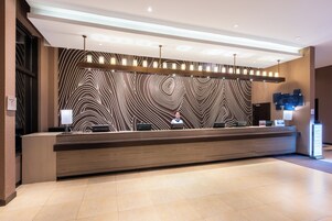 Una recepción con diseño moderno, pared con estampado y piso cubierto de baldosas limpias.