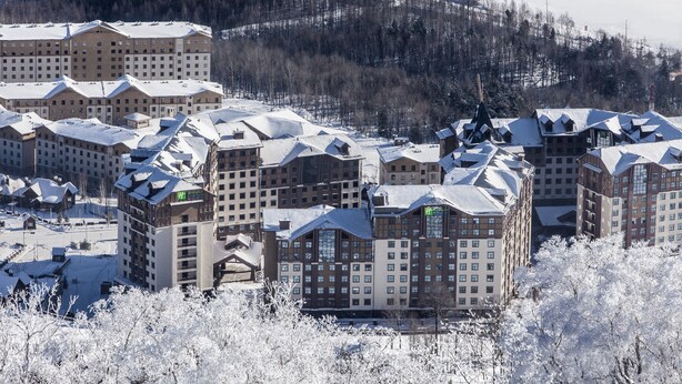 A hotel complex with multiple buildings, each featuring a snow-covered roof and a central courtyard. - Holiday Inn Express Changbaishan by IHG (Baishan)