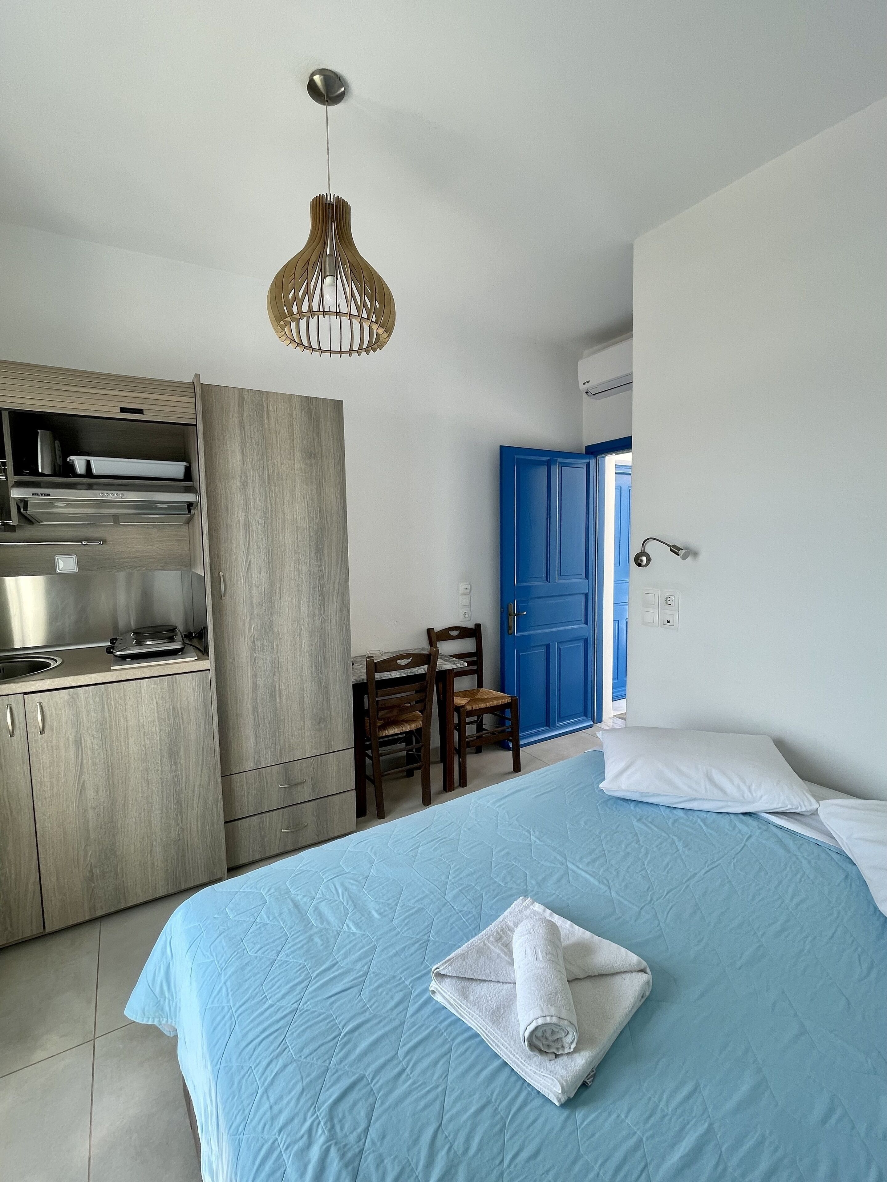 Une chambre moderne équipée d’un lit, d’un bureau et d’une kitchenette.