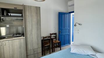 Une chambre moderne équipée d’un lit, d’un bureau et d’une kitchenette.