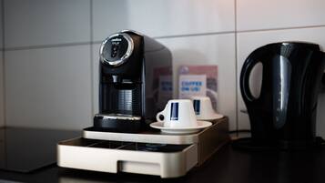 Une machine à café avec une tasse et une soucoupe posées sur un comptoir.