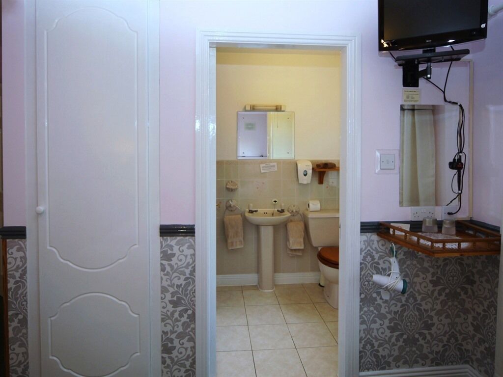 A bathroom with a sink, toilet, and mirror.