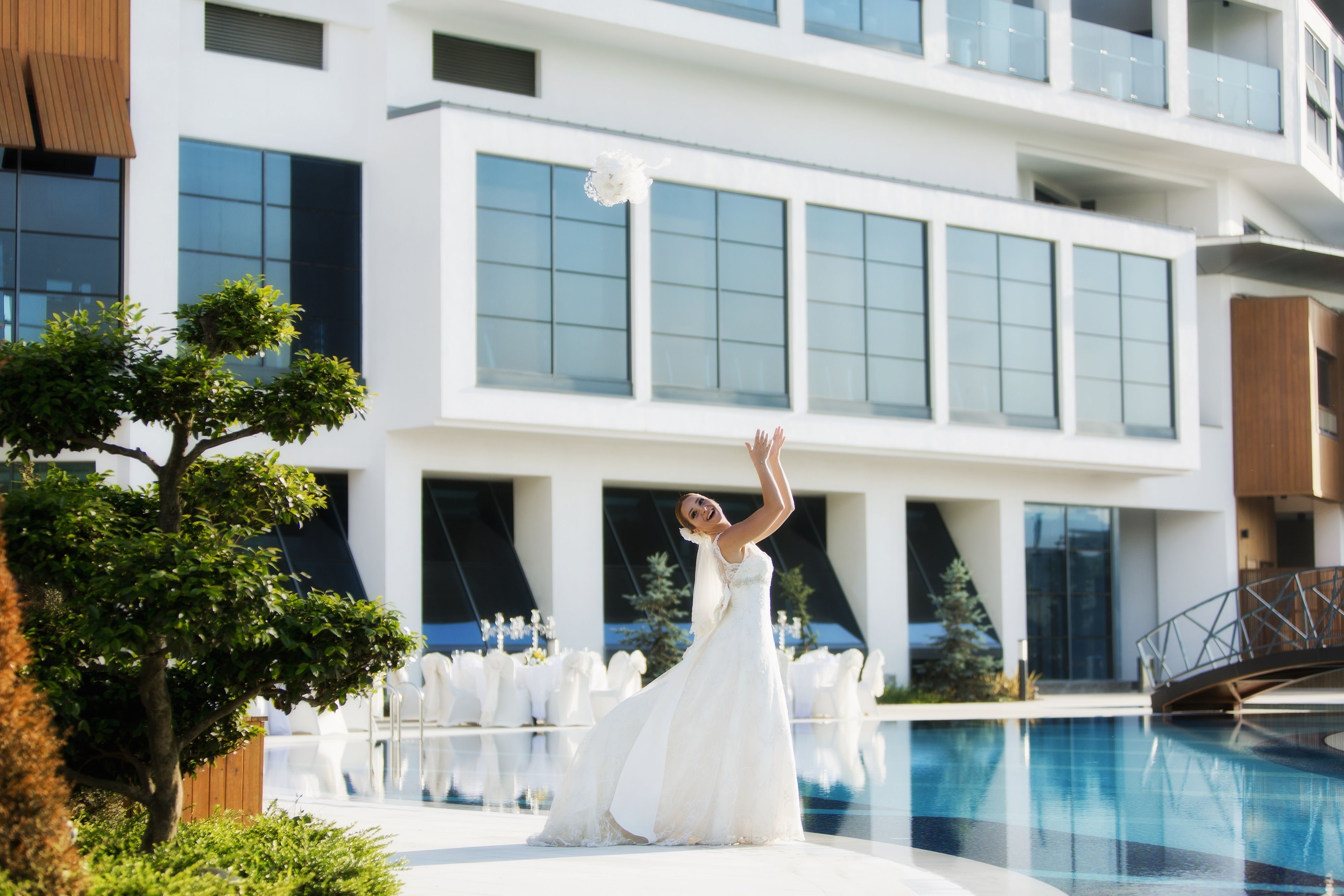 A modern building with large windows and a pool area.