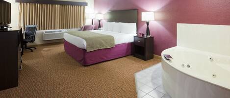 A hotel room with a bed, a desk, a chair, an air conditioner, a bathtub, and a window with curtains.