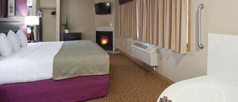 Una habitación de hotel con cama, chimenea, televisor y baño con bañera.