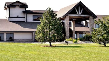 Stunning two-story house with a gabled roof and brick facade, set amidst a beautifully manicured lawn.