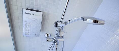 A shower with a handheld showerhead and a wall-mounted control panel.