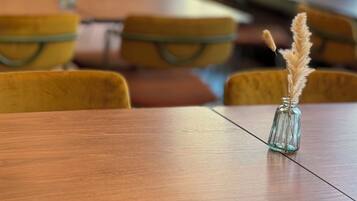 A dining area with wooden tables and yellow chairs.