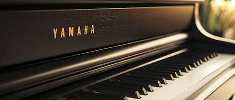 Un piano Yamaha con acabado negro y teclas blancas.