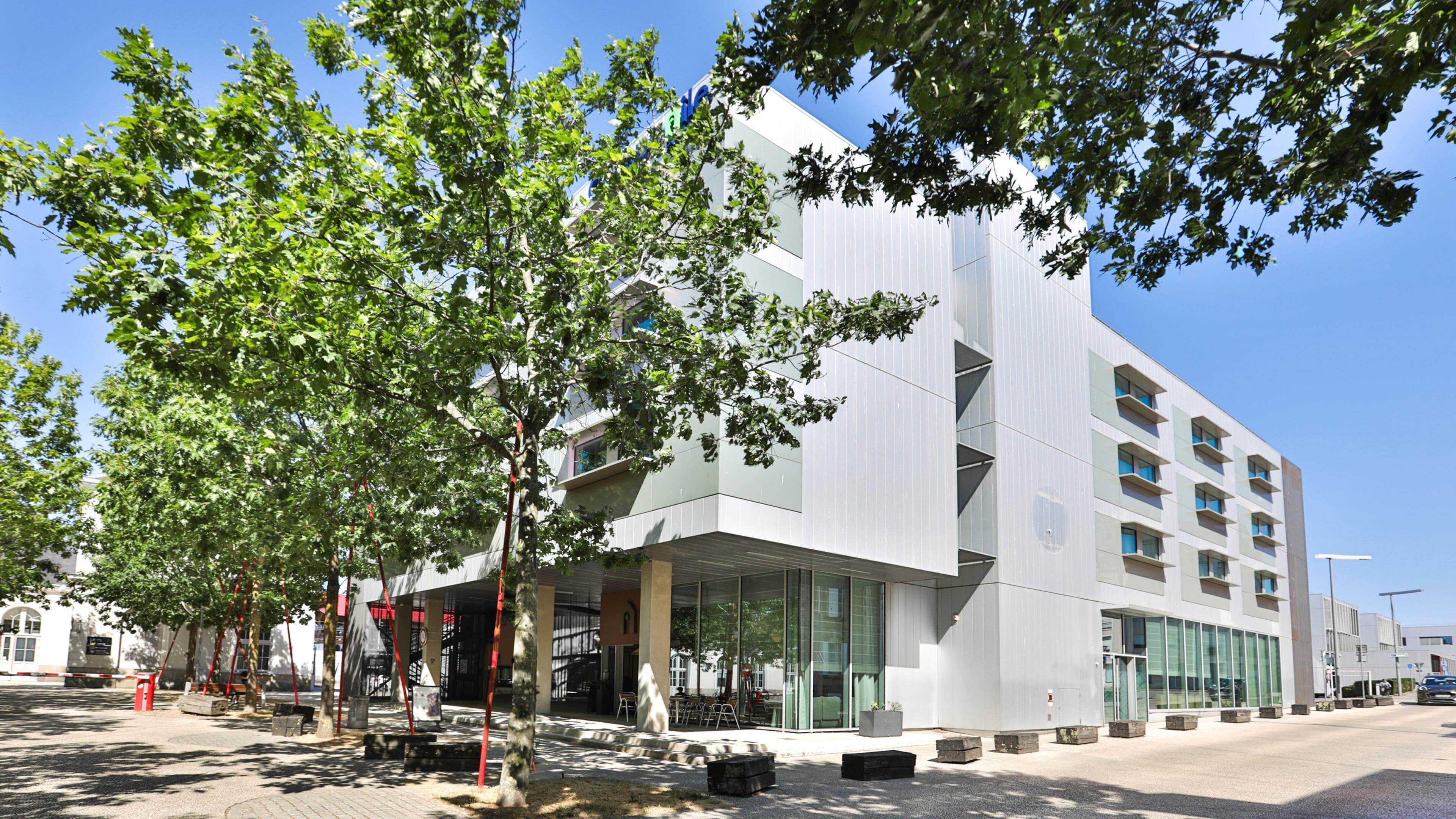 Un edificio moderno con fachada de vidrio, techo plano y varias terrazas.