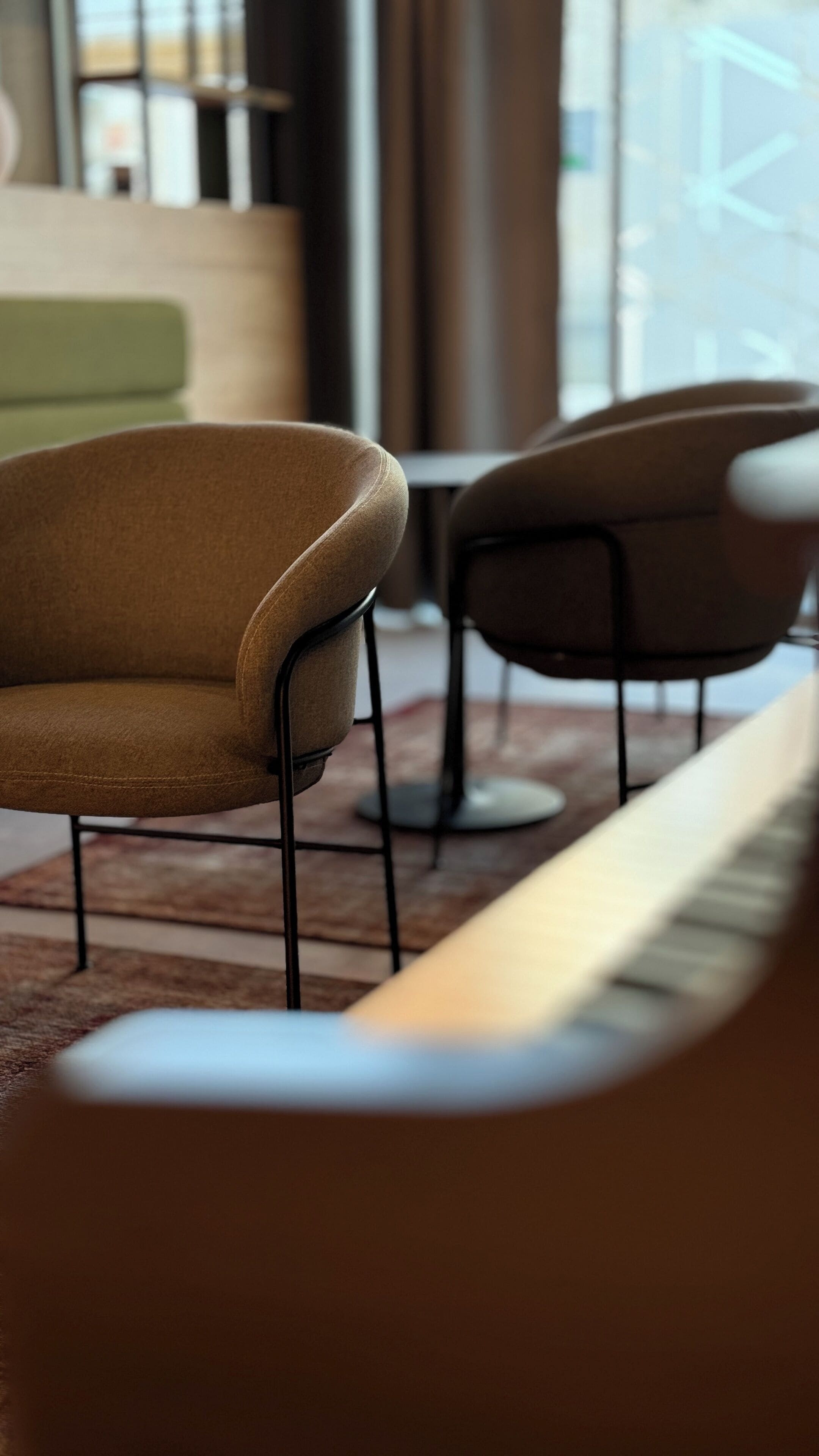 A modern interior with a seating area featuring chairs with metal frames and a long bench.