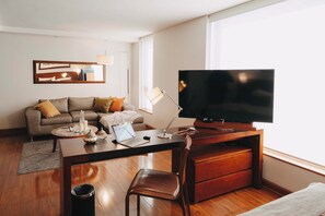 Apartament superior, 1 dormitori | Sala d'estar | Televisor intel·ligent de 50 polzades amb canals per cable i televisor 