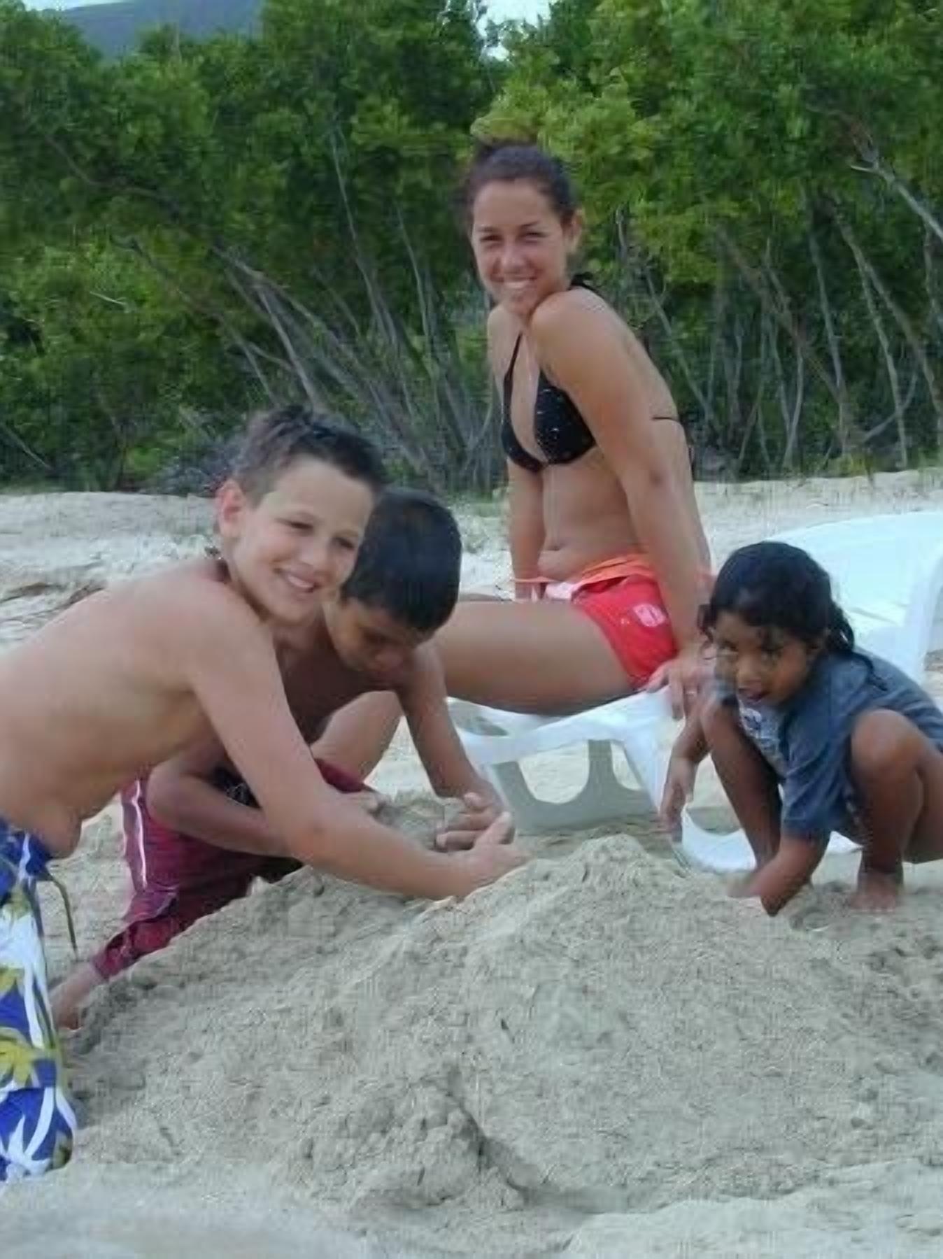 A beach scene with people playing in the sand.
