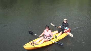 Two people kayaking on a calm body of water.
