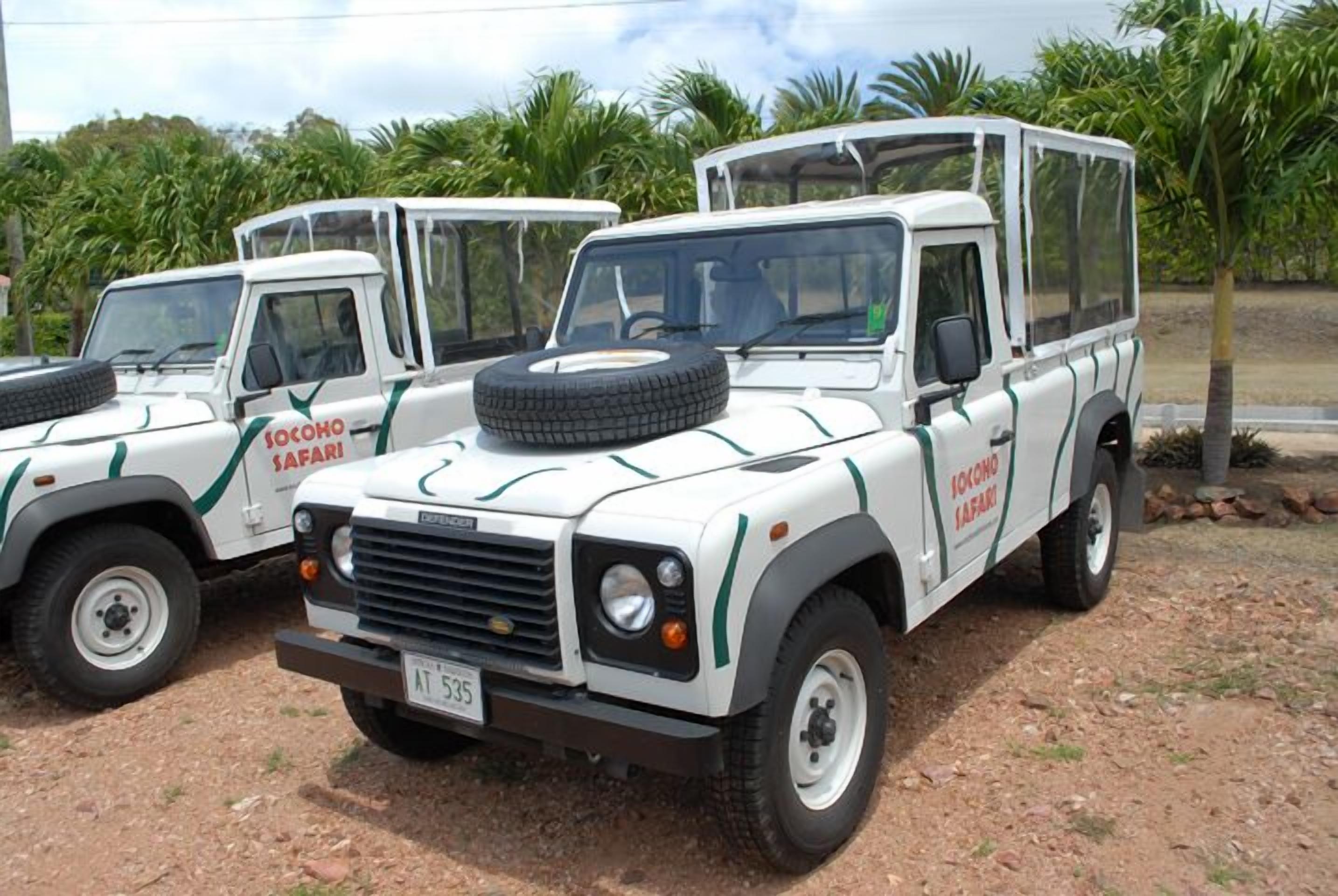 Two safari vehicles with "Socono Safari" branding parked on a dirt surface.