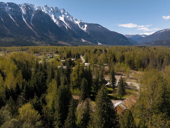A mountainous landscape with a valley and scattered buildings.