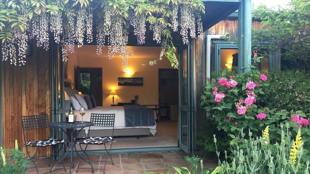 Une chambre à ciel ouvert avec un lit, une table et des chaises.