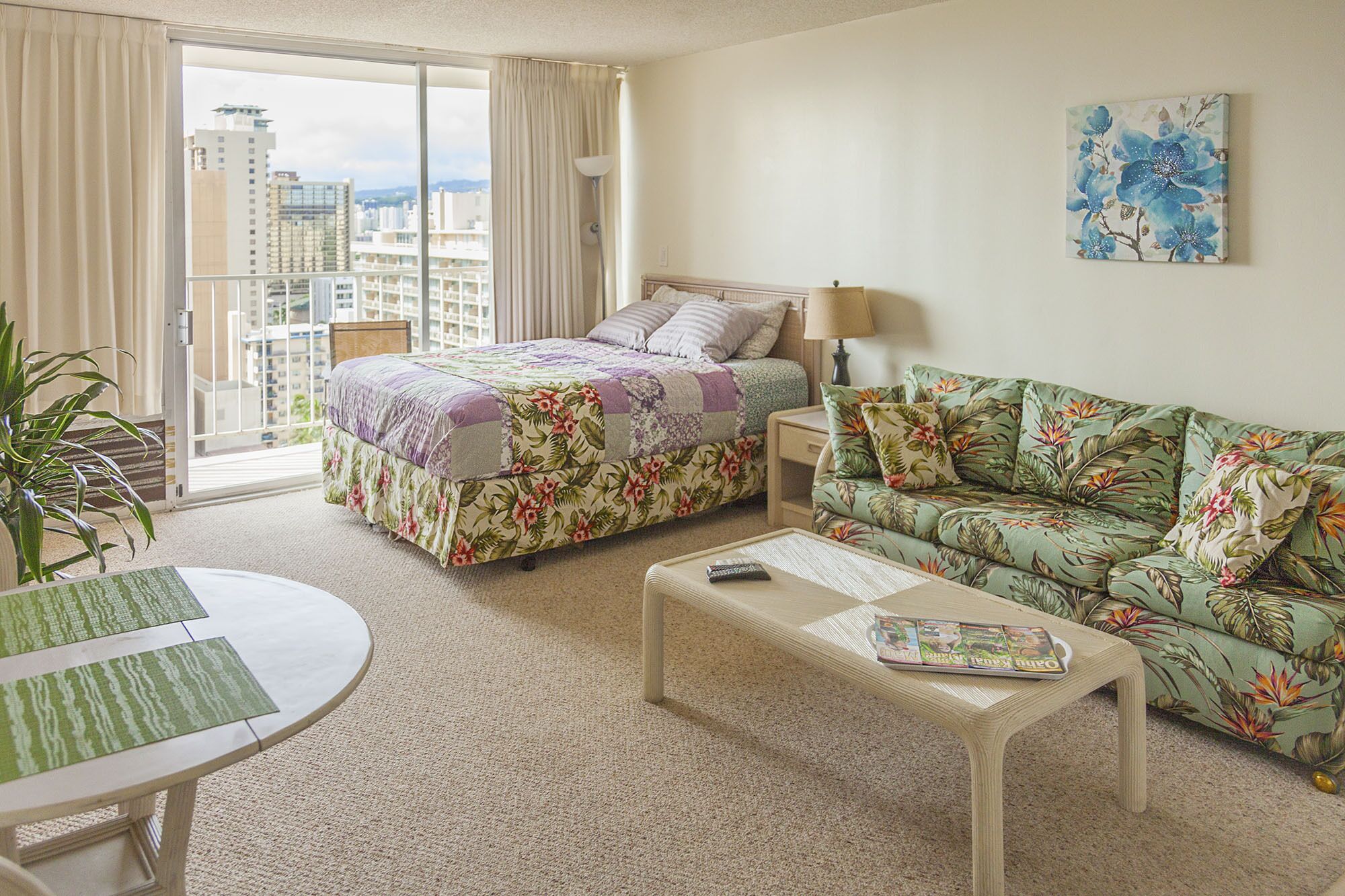 Habitación de hotel con cama, sofá, mesa de centro y vista a la ciudad.