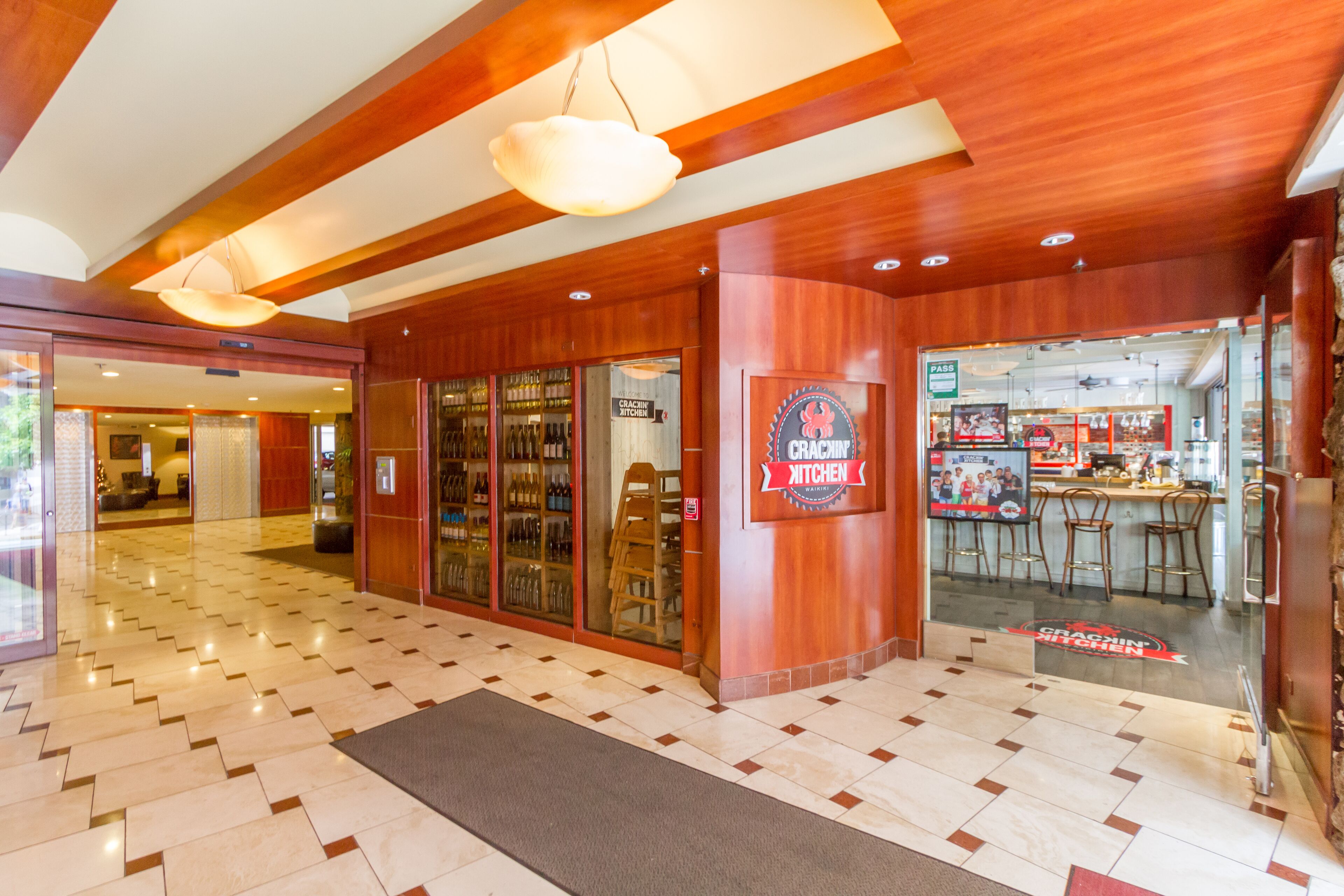 A modern interior with a bar area, wooden ceiling, and a tiled floor.