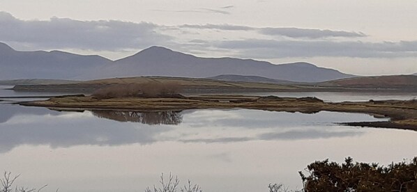 A calm lake with mountains in the background. - Elmgrove Apartments (Westport)