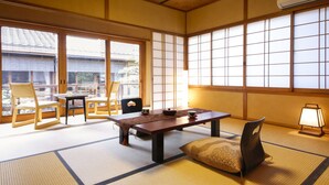 Una habitación japonesa tradicional con suelo de tatami, una mesa baja y paneles shoji.